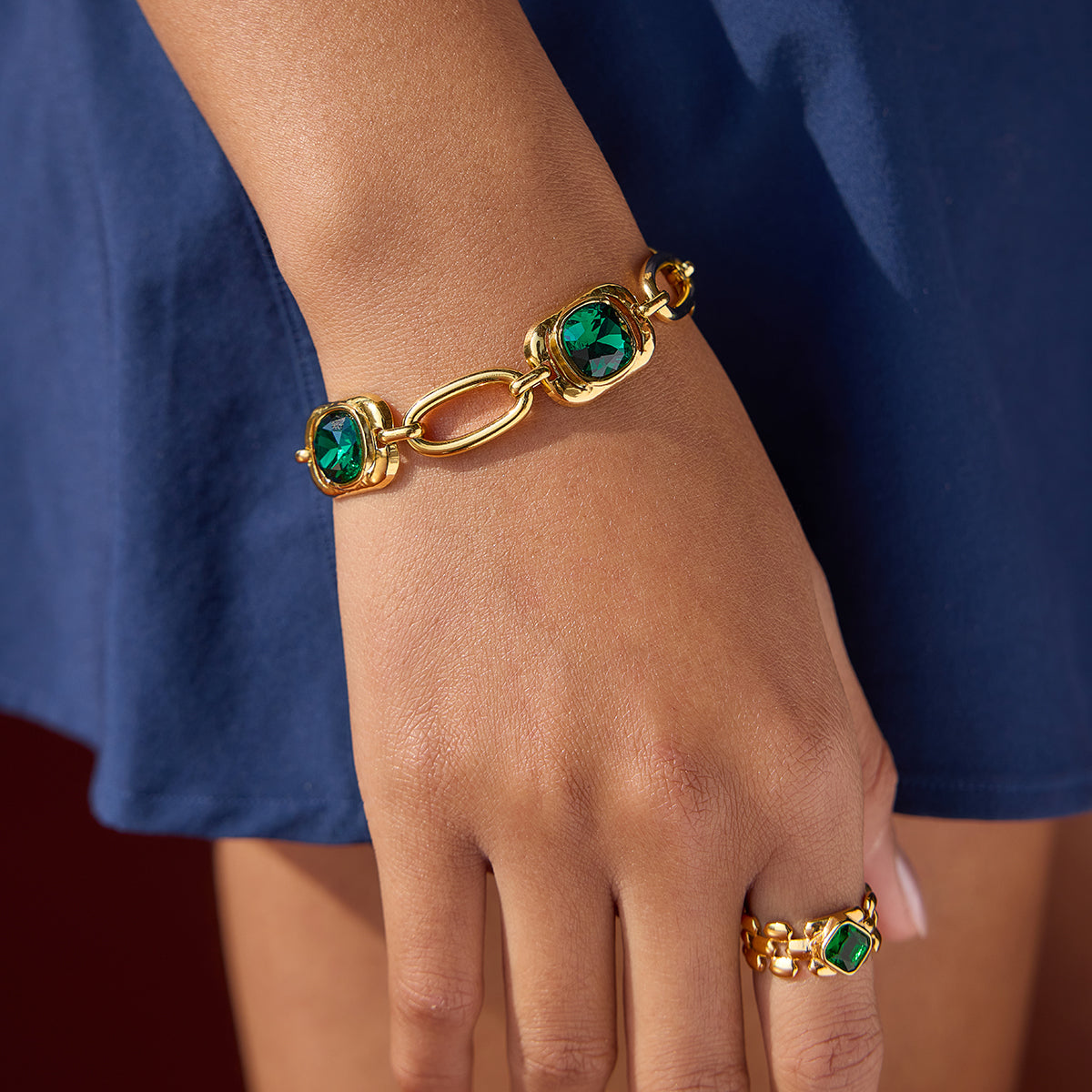 Emerald green stone bracelet on a model wearing a blue outfit