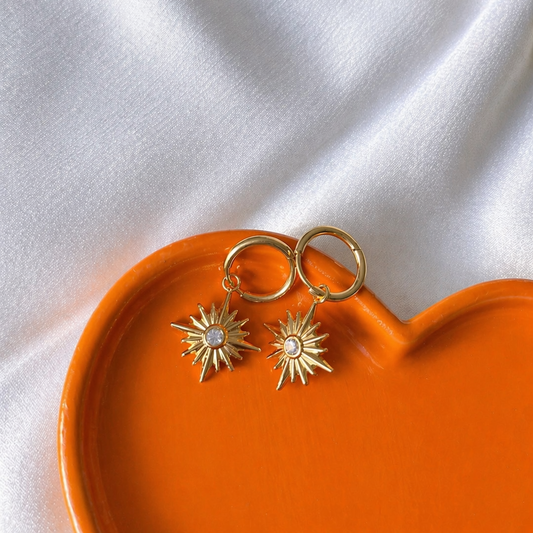 Gemstone Drop Earrings on a orange heart platter against a white background
