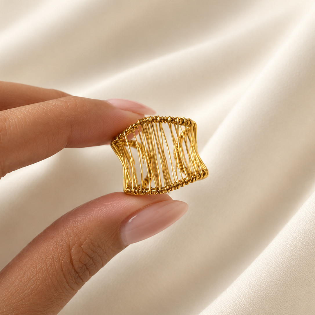 Gold Jaali Ring with intricate openwork wire design, photographed on ivory satin fabric.