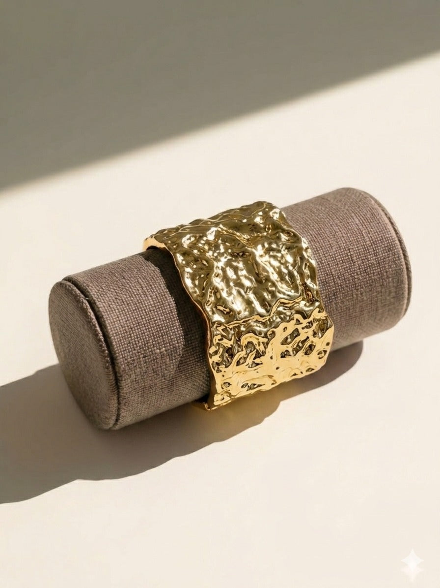 Metallic gold cuff bracelet with a soft shadow