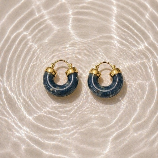 Pair of blue hoop earrings with gold accents on a resin look