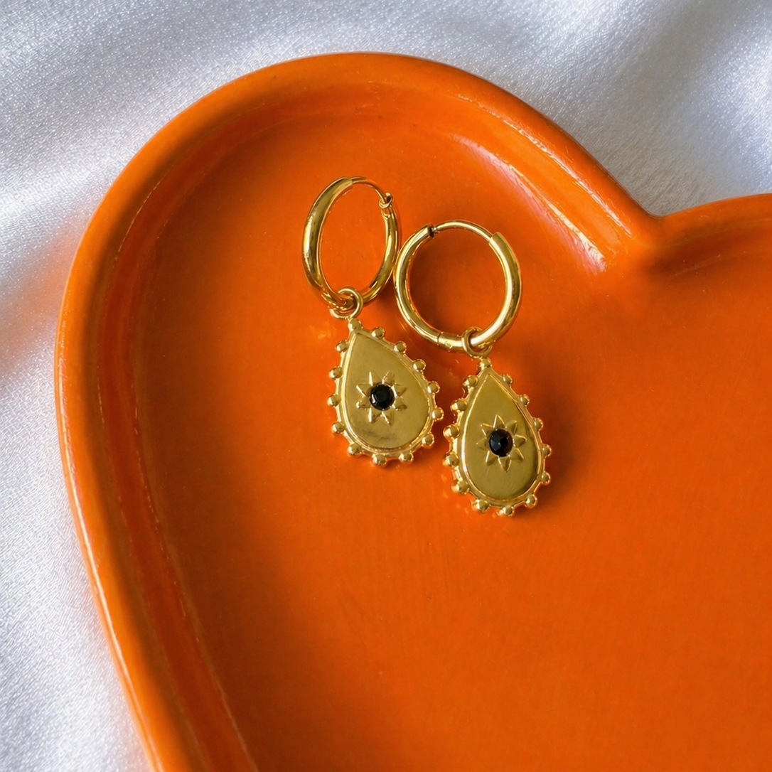 Teardrop with a blackstone centre hoops against a orange and white background