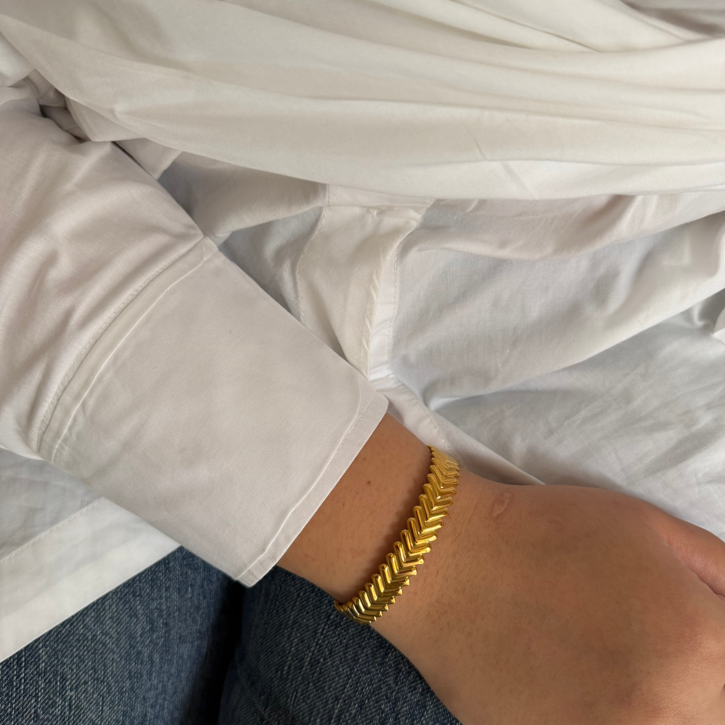 Teer Golden Cuff Bangle  worn by a model wearing a white whsirt 