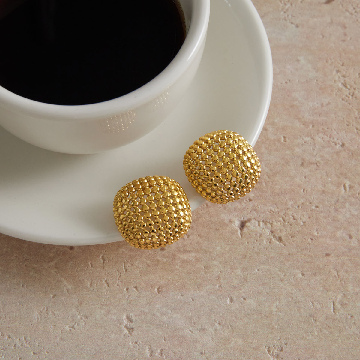 Textured stud earrings with a honeycomb-inspired circular pattern