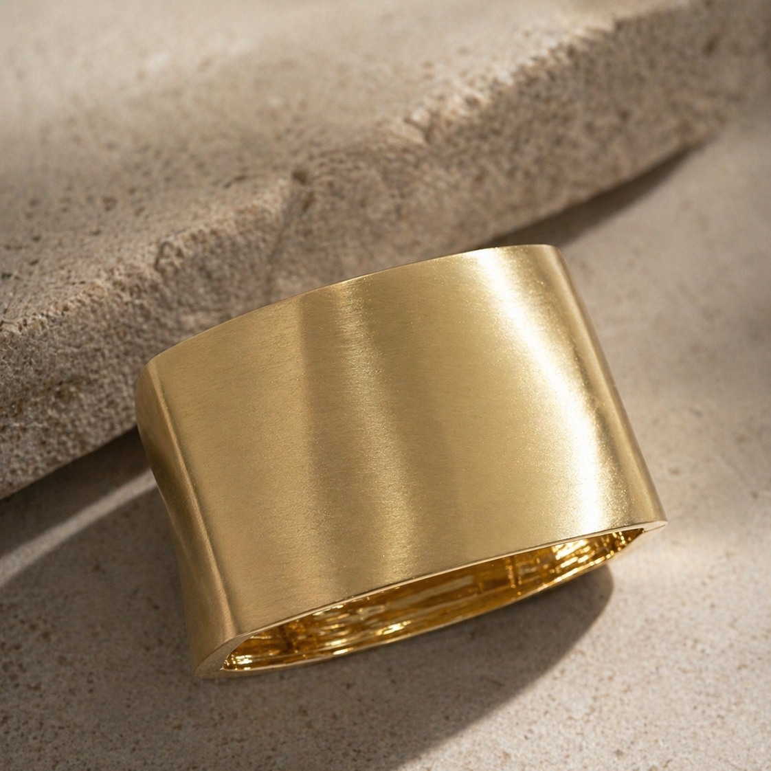 Gold bracelet on a textured stone surface
