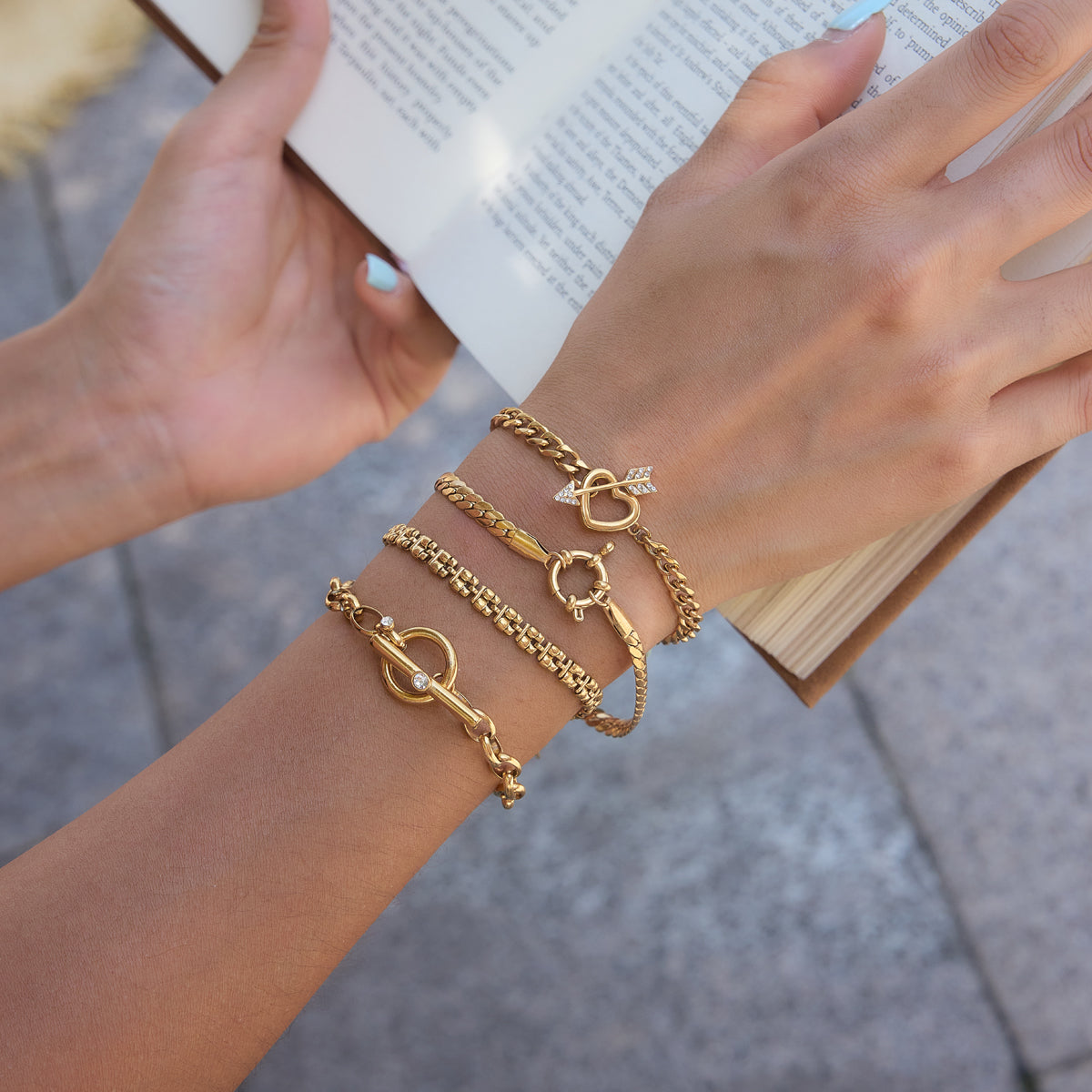 A hand is showcased with a stack of bracelets, which also includes our Zari Bracelet. 