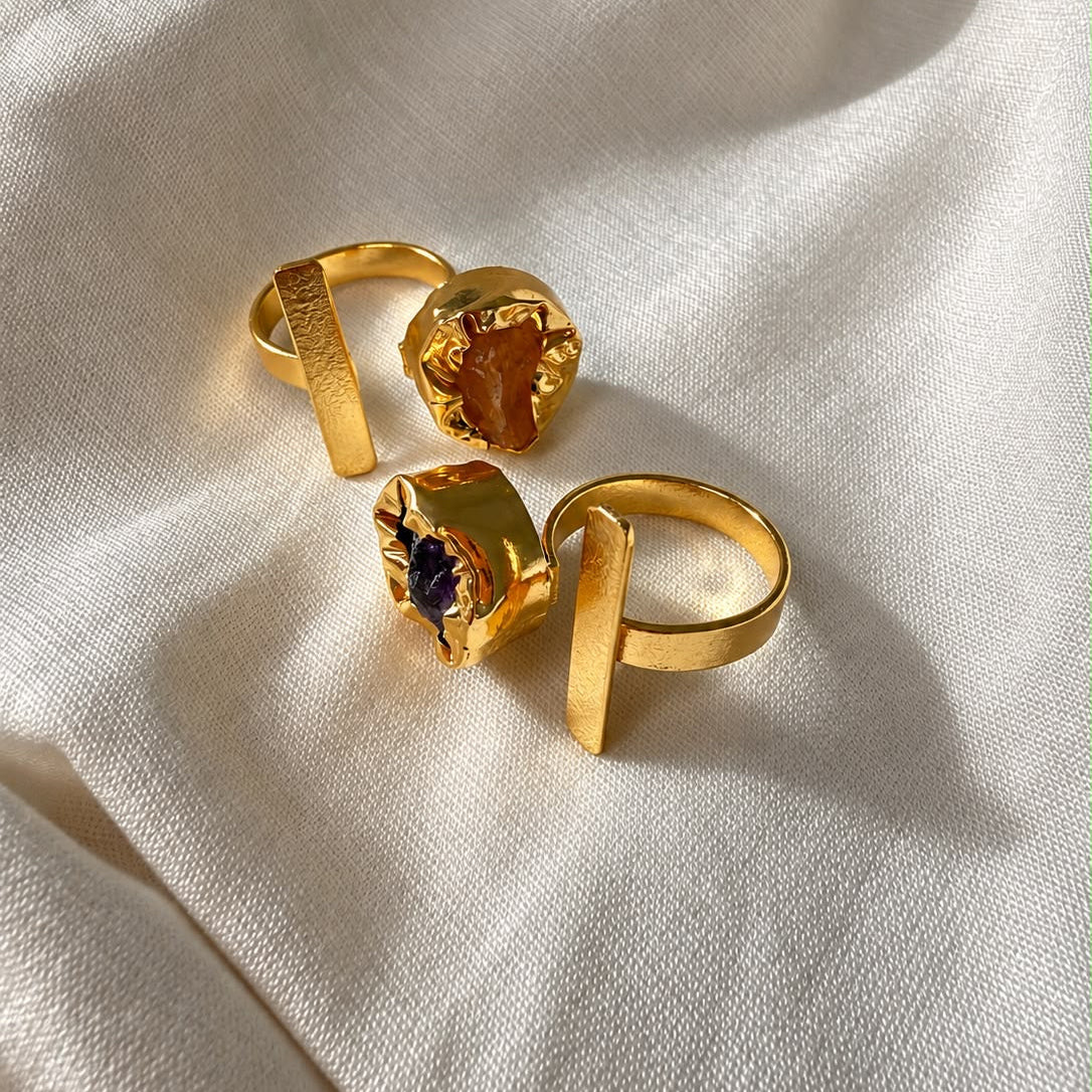 Two Ada statement rings resting on folded cream fabric in natural light