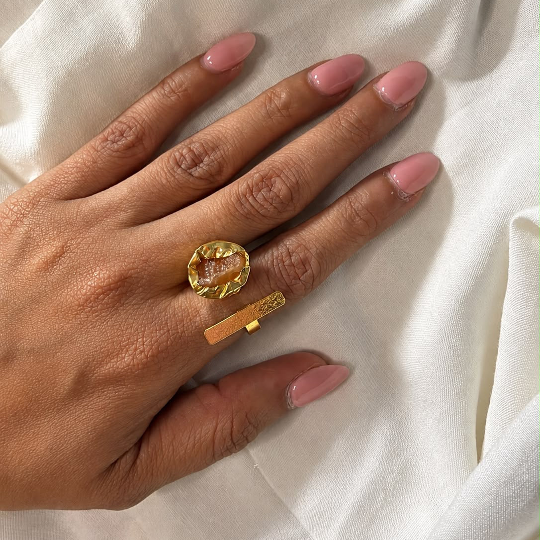 Ada Ring with an amber-orange natural stone and a textured gold-finish bar on a hand