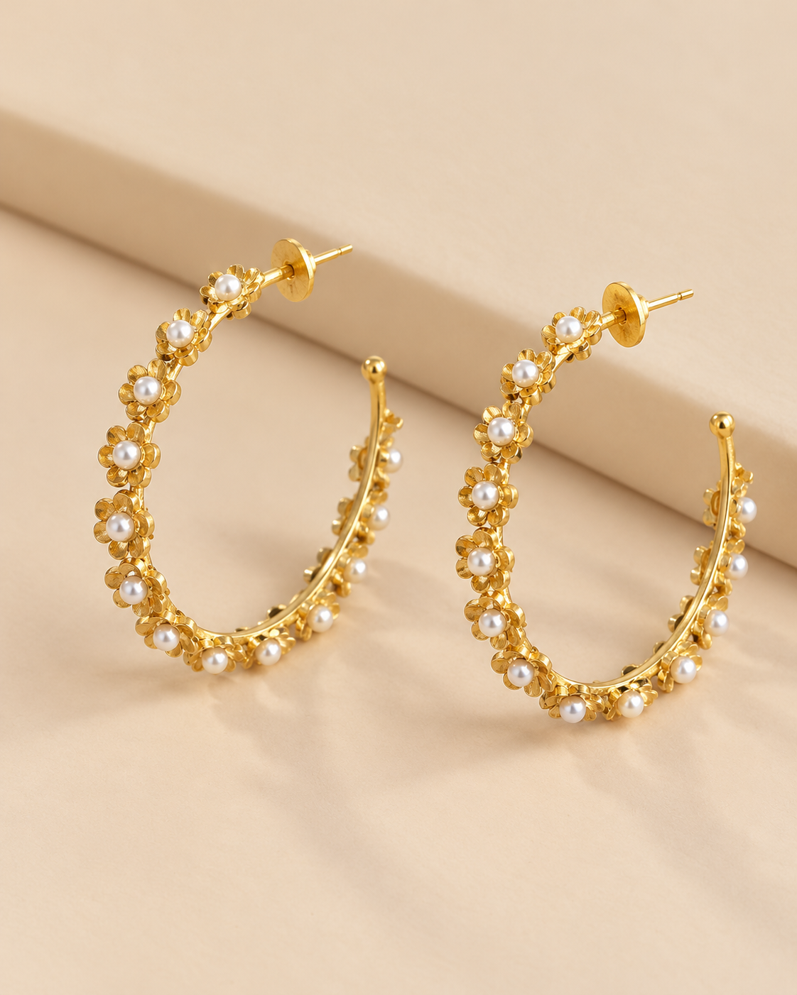 Phool Hoop flower and pearl earrings arranged side by side on a soft cream surface