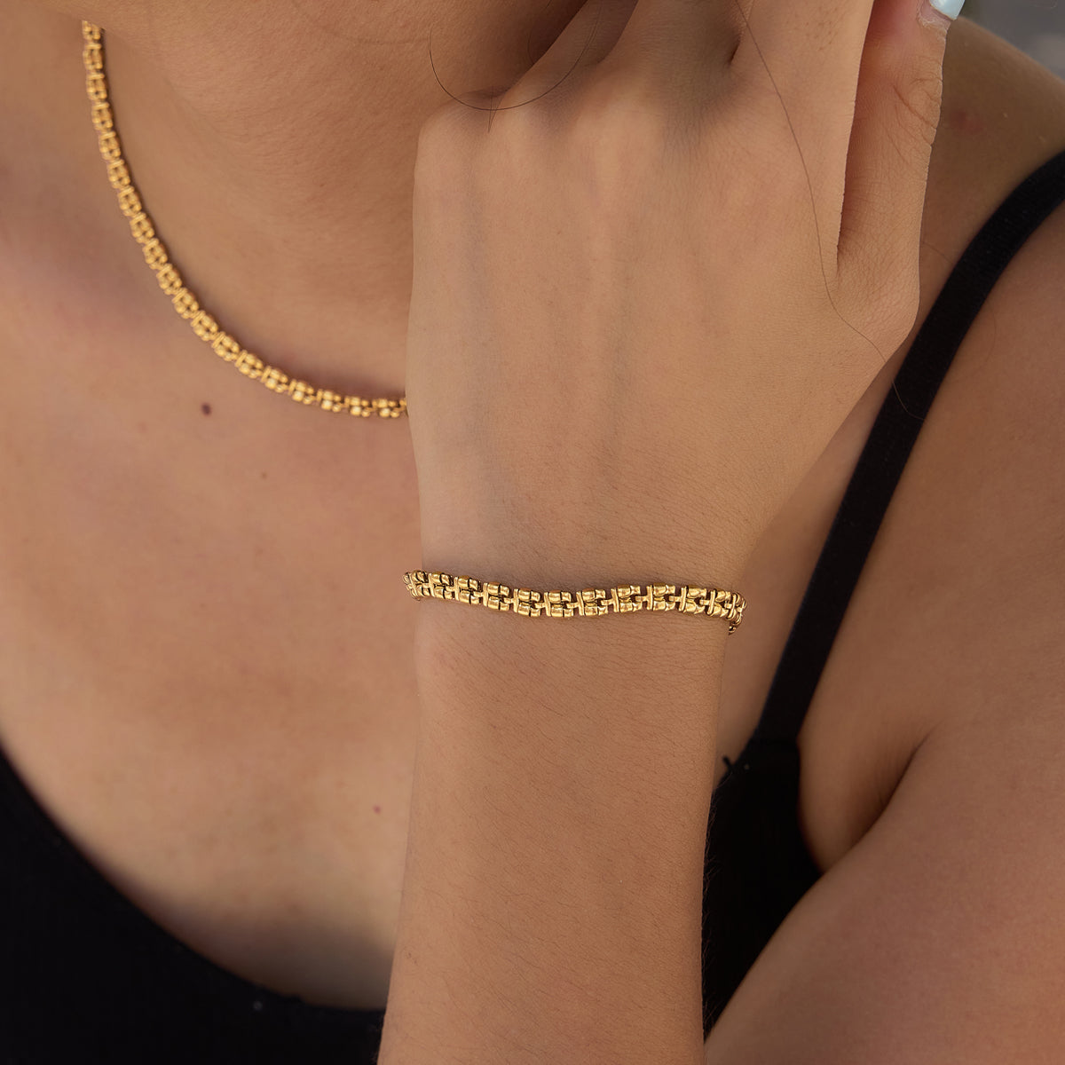 Front view of the Zari Necklace showing its textured gold-toned interlocking links