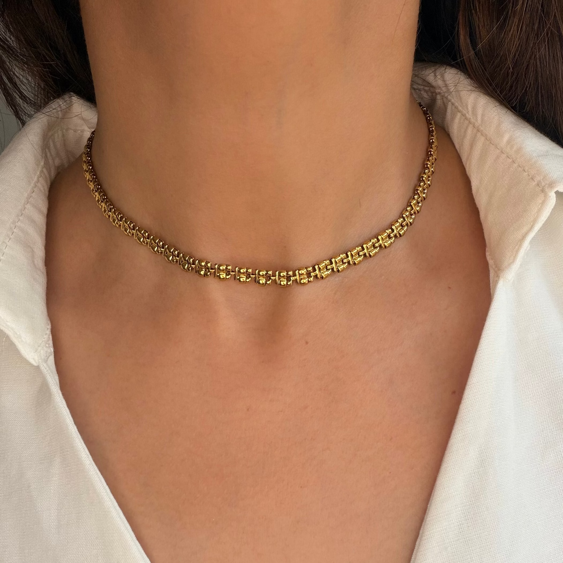 Zari Necklace worn along the collarbone with an open white shirt